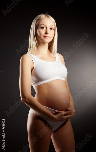 Pregnant Woman over dark background © evasilchenko