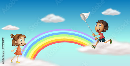 Happy kids near the colorful rainbow