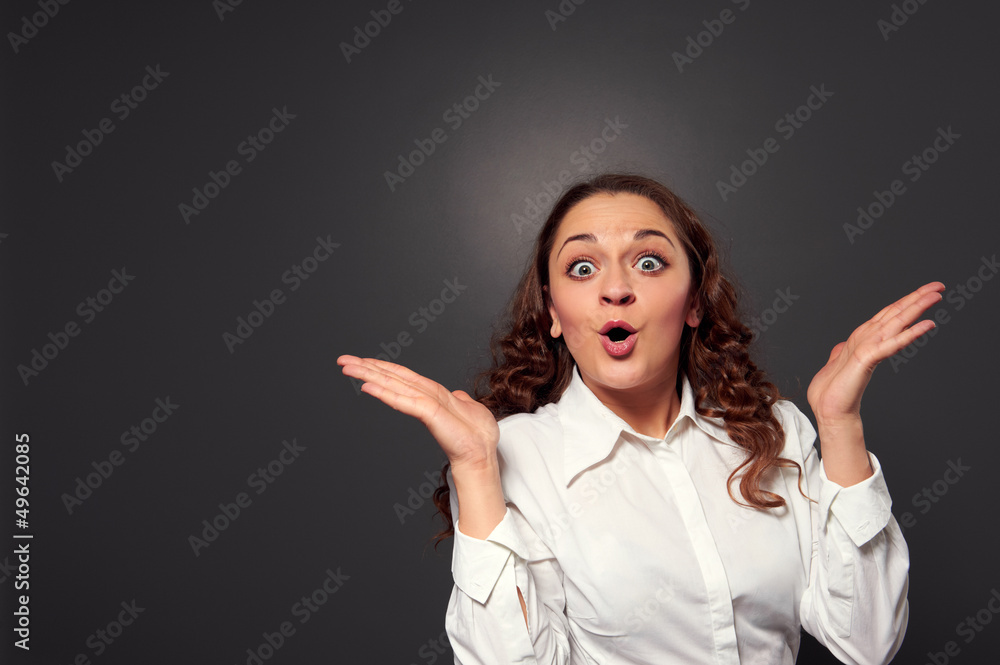 amazed young woman over dark grey amazed young woman over dark grey