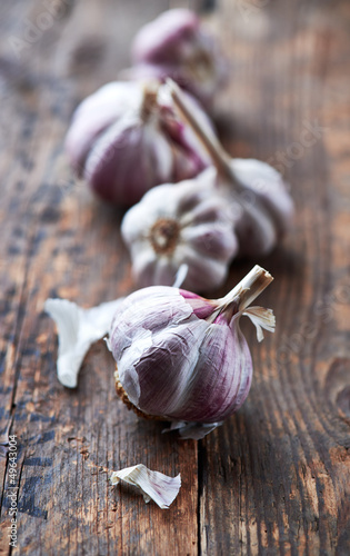 Foto Garlic bulbs on old wooden surface