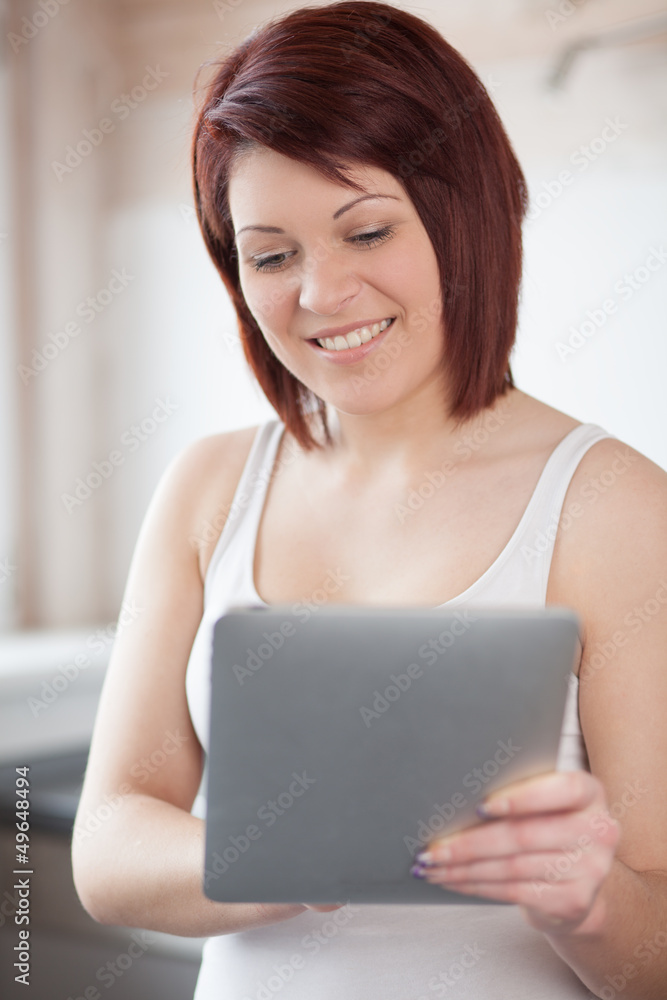 Young woman with tablet in kitchen