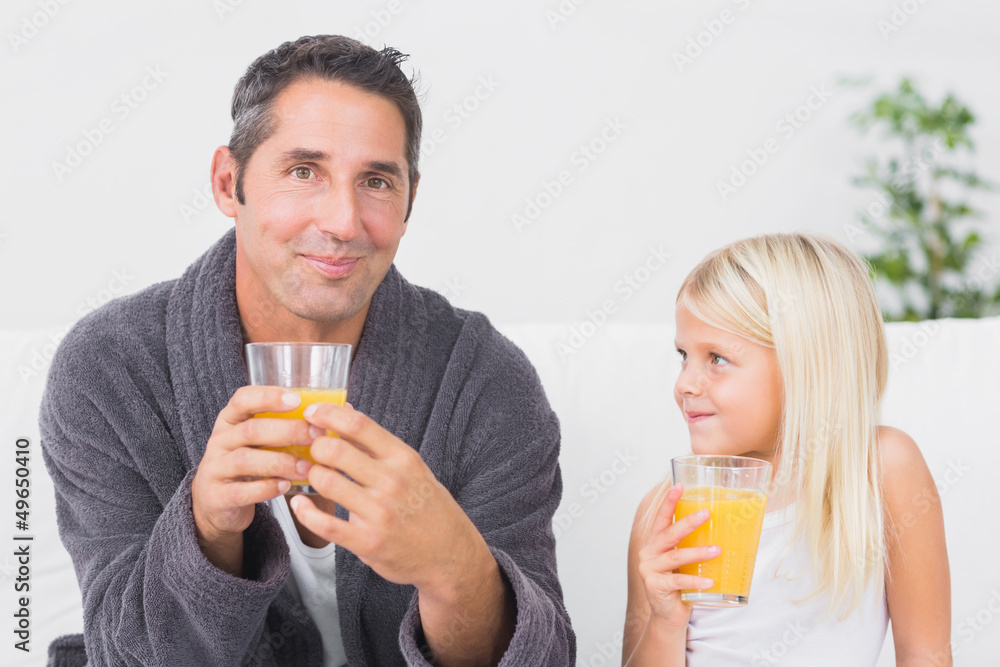Father and daughter drinking glass of orange juice Father and daughter drinking glass of orange juice