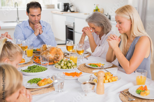 Family praying before dinner