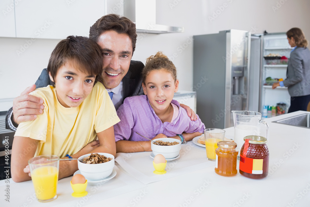 Happy father and children at breakfast