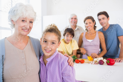 Grandmother and granddaughter standing beside counter