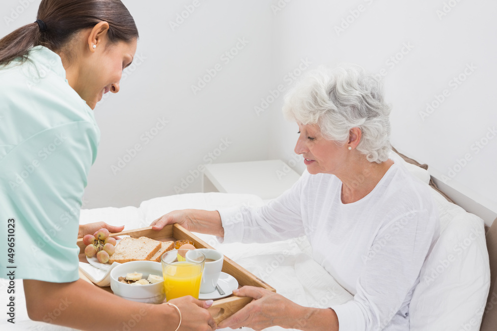 Elderly woman taking a breakfast with home nurse Elderly woman taking a breakfast with home nurse