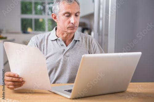 Calm mature man using his laptop