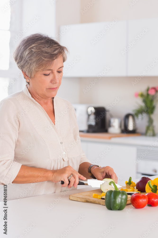Old woman cutting vegetables on a cutting board Old woman cutting vegetables on a cutting board