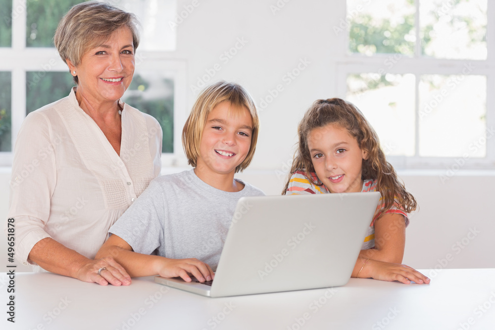 Grandmother and children looking at the camera together with lap Grandmother and children looking at the camera together with lap