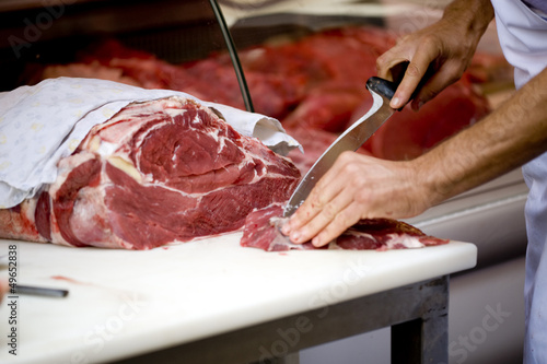 butcher cutting meat photo