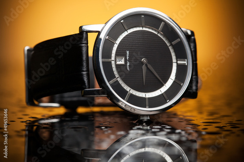luxury watches with a leather strap on the orange background