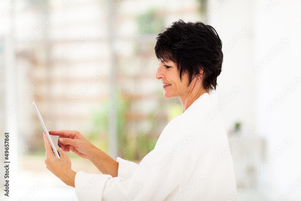 cute mature woman using tablet computer at home cute mature woman using tablet computer at home