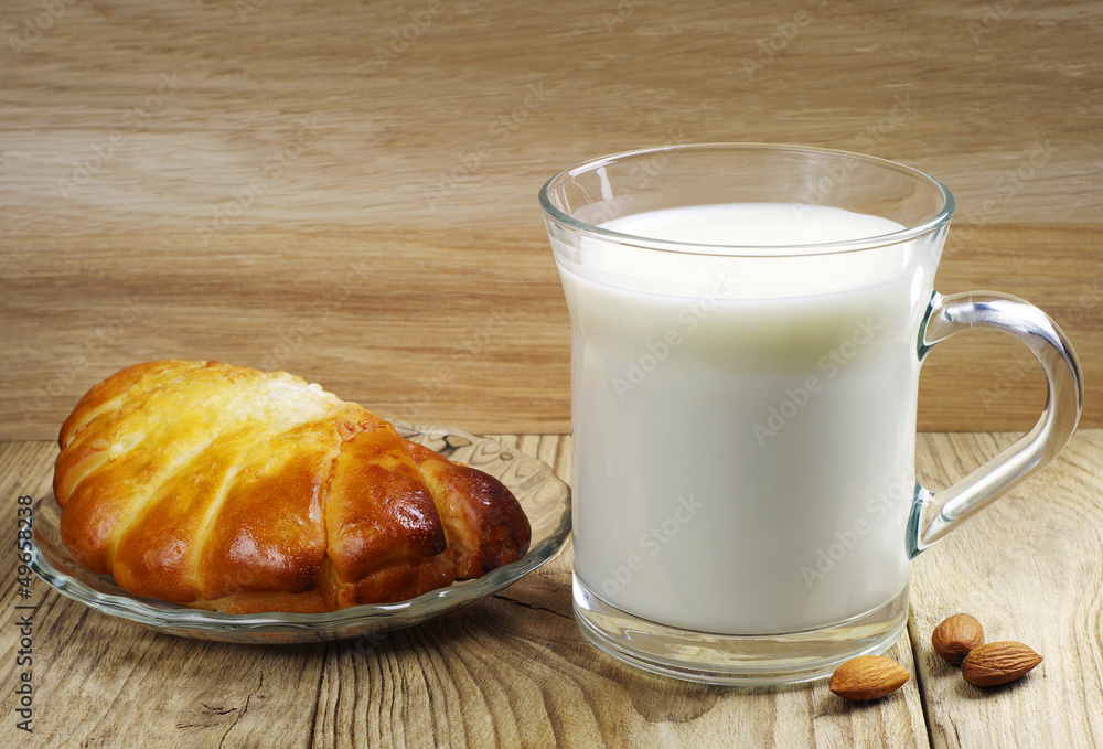 Transparent glass cup with milk and bun Transparent glass cup with milk and bun