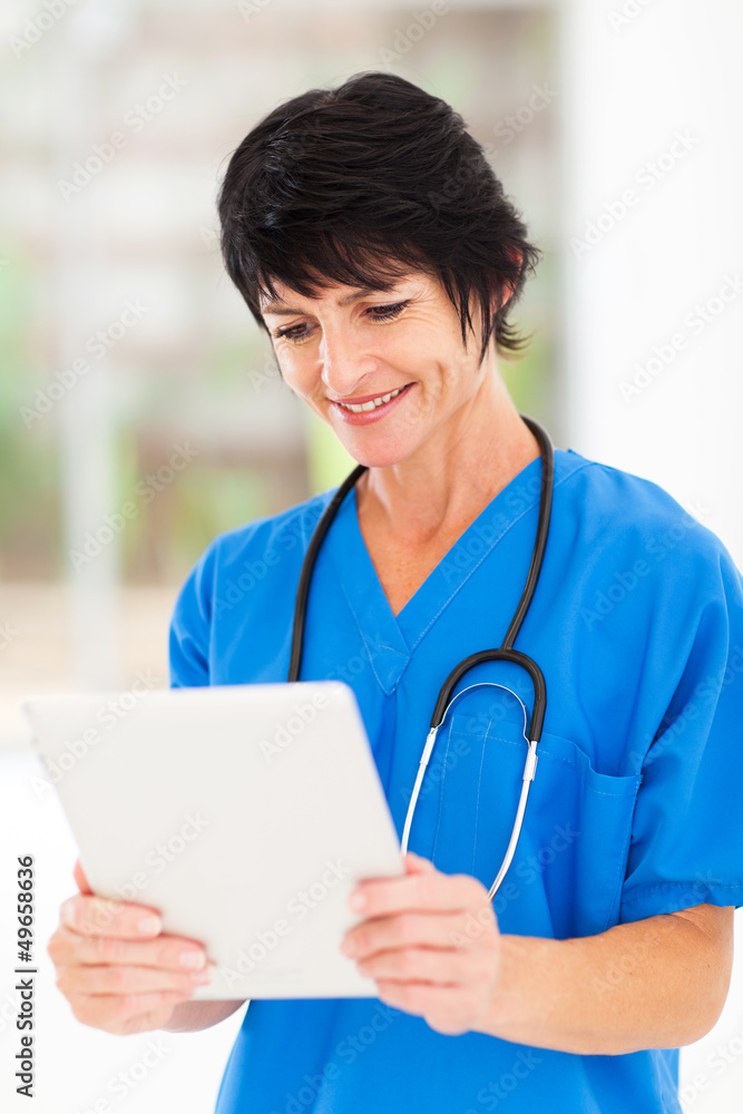 happy middle aged medical worker using tablet computer in office happy middle aged medical worker using tablet computer in office