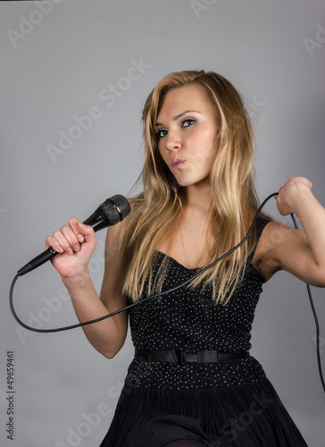 Young blond woman sing with microphone