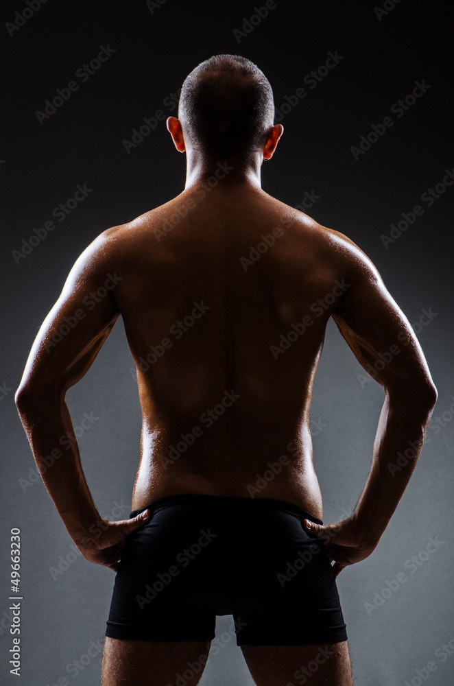 Fototapeta premium Muscular man in dark studio