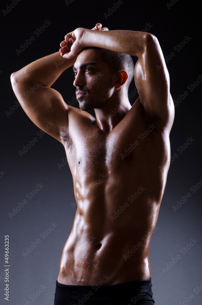 Muscular man in dark studio Muscular man in dark studio