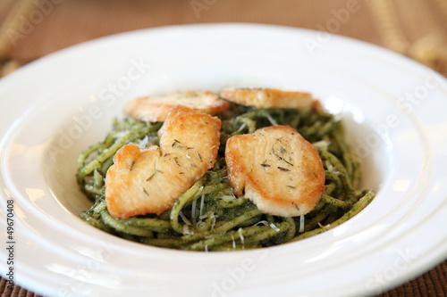 spaghetti with pesto sauce on wood background