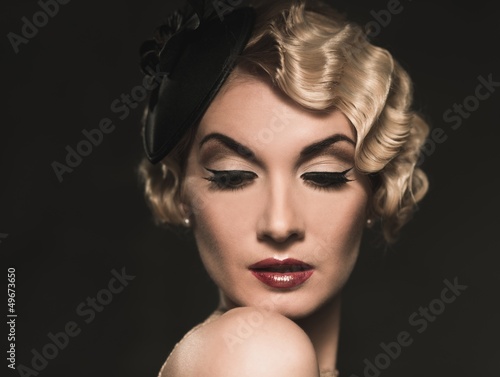 Elegant blond retro woman wearing little hat