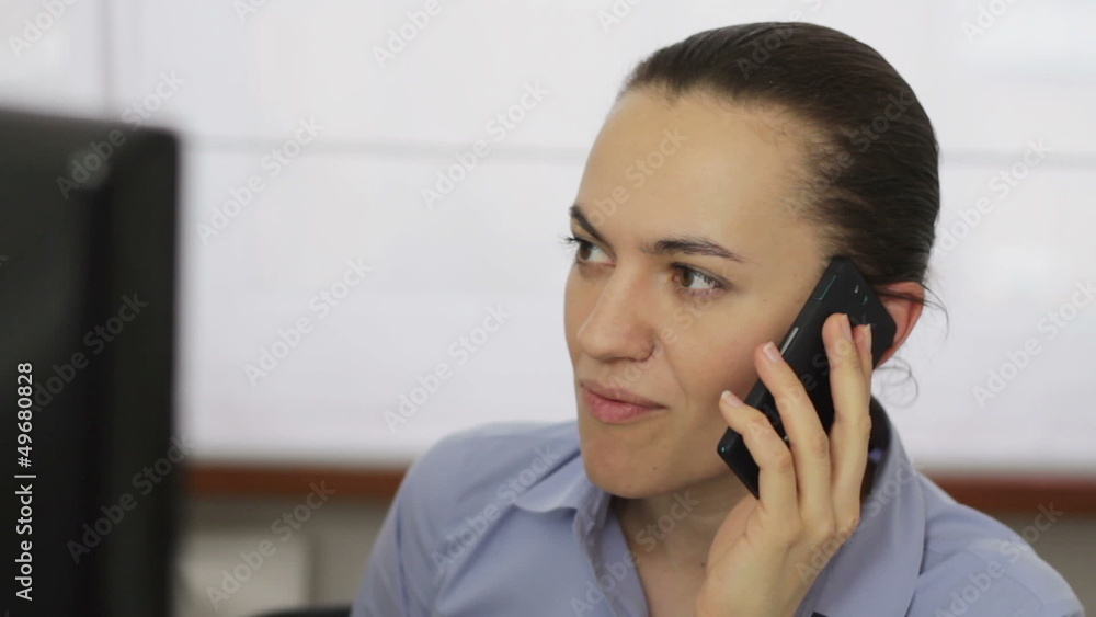 Woman talking on cellphone in front of the computer, close up Woman talking on cellphone in front of the computer, close up