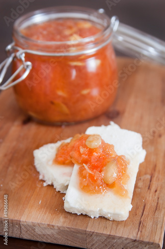 Sweet quince jam with almonds on white cheese