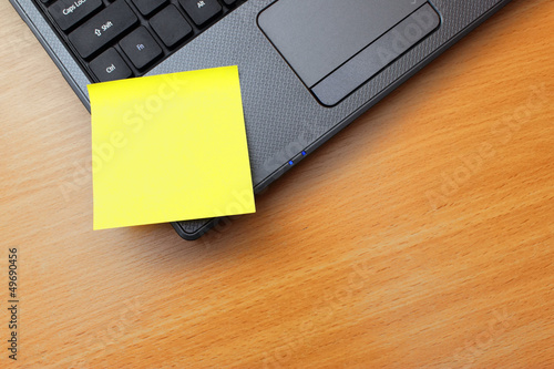 Blank orange post it notes on a laptop PC