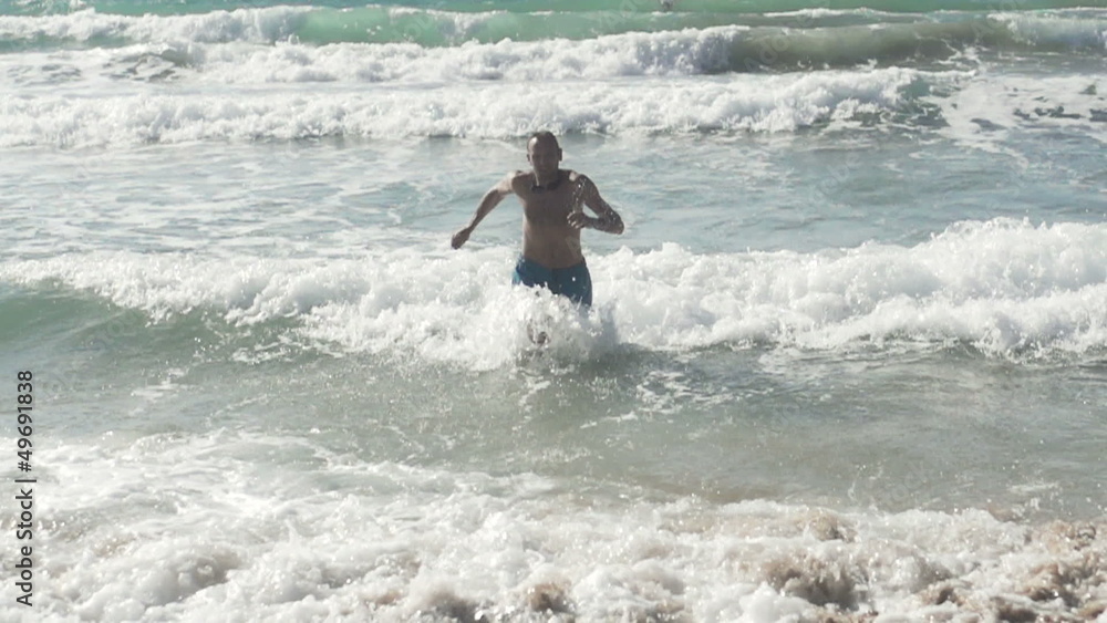 Man running out of the sea, super slow motion, shot at 480fps Man running out of the sea, super slow motion, shot at 480fps