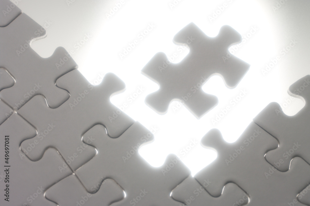 Fitting jigsaw puzzle pieces against the light. Fitting jigsaw puzzle pieces against the light.