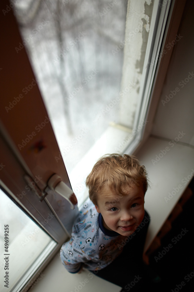 Smiling boy sitting on the windowsill. Smiling boy sitting on the windowsill.