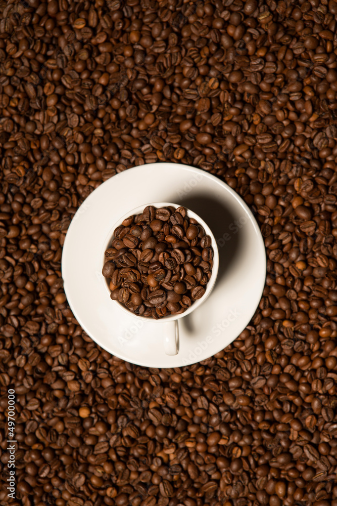 Naklejka premium cup with coffee beans on a dark background