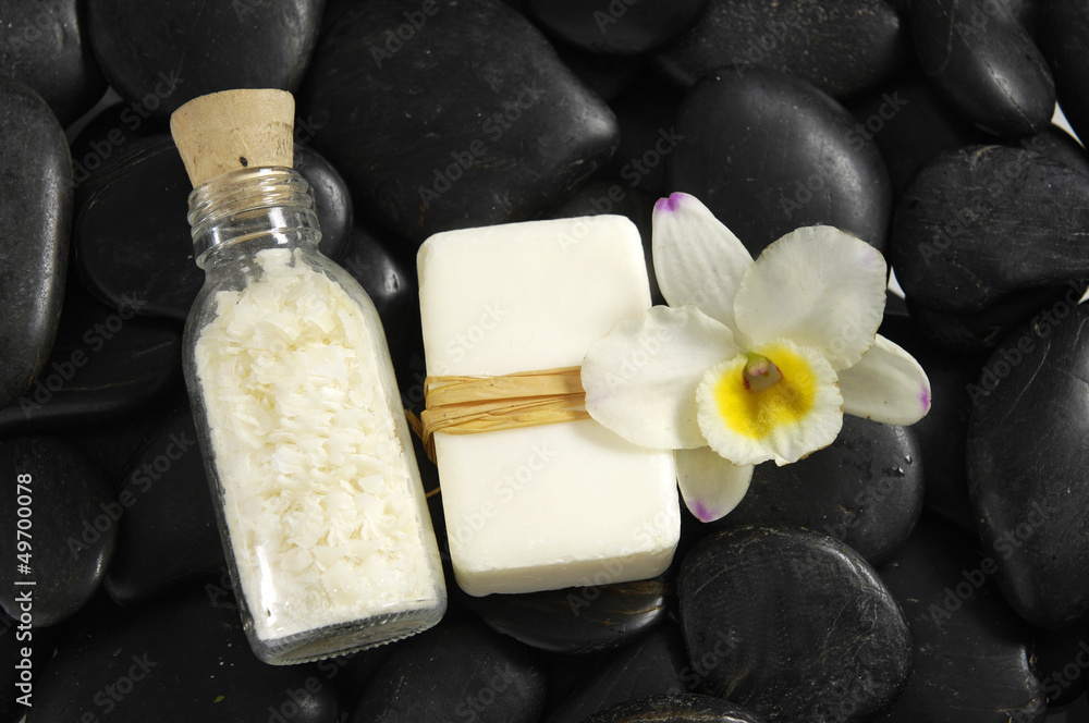 White orchid and candle with soap on zen stones background