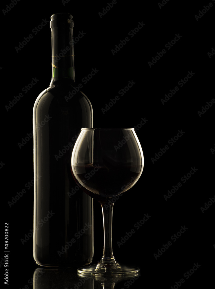 Red wine bottle and glass on black background Red wine bottle and glass on black background