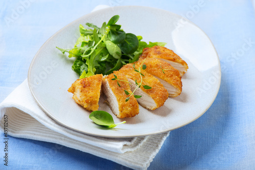 fried, breaded chicken fillet with fresh salad