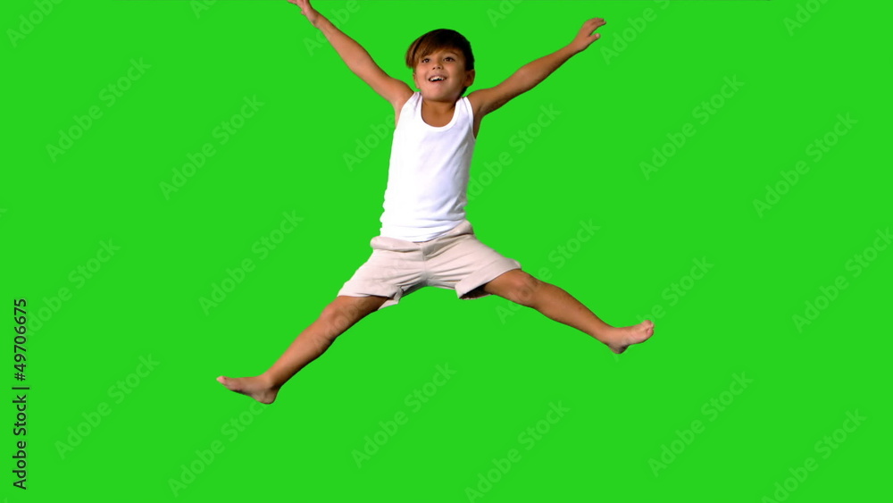 Happy little boy jumping on green screen Happy little boy jumping on green screen