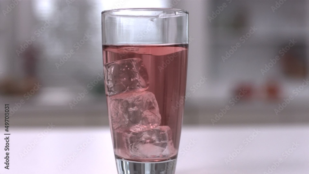 Four ice cubes spinning in a glass of juice Four ice cubes spinning in a glass of juice