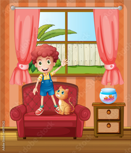 A boy standing at the sofa inside the house