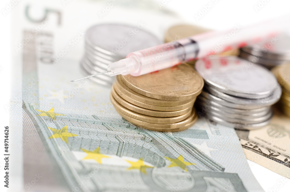 Syringe with liquid on money Syringe with liquid on money