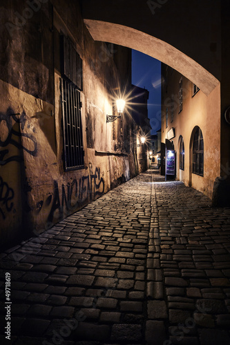 Fotografie narrow alley with lanterns in Prague at night