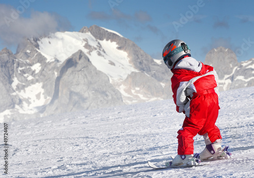 Little skier on a ski slope in The Alps.