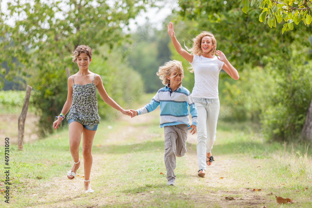 Fototapeta premium Beautiful Young Woman with Two Children Outside