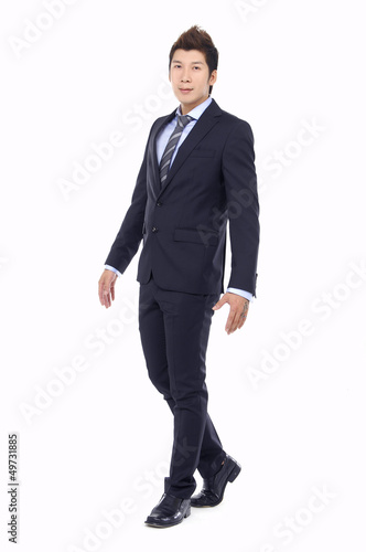 Full body portrait of walking young business man