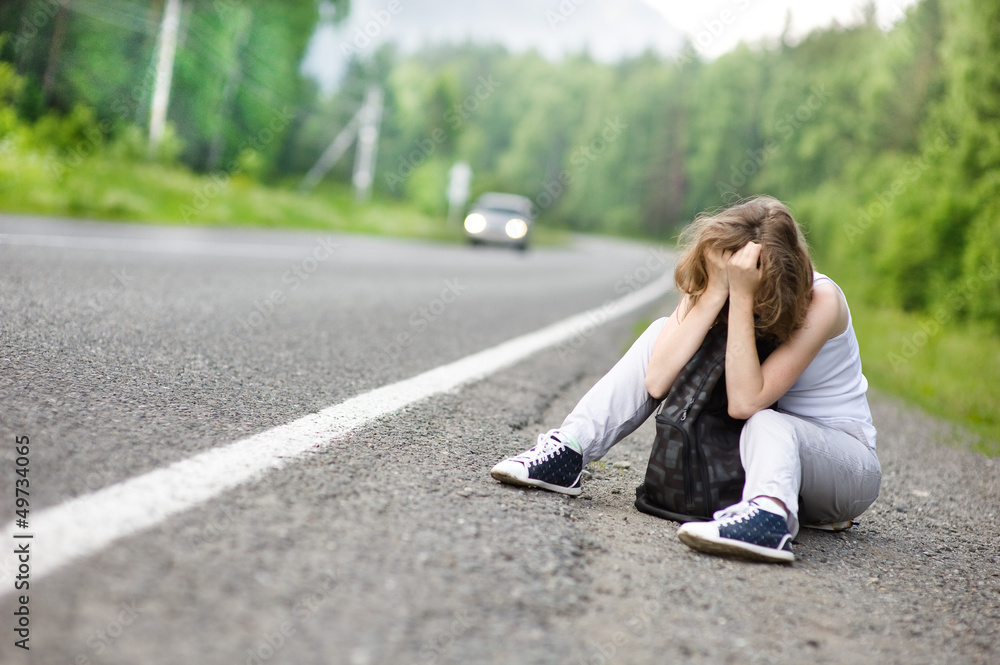 the sad girl hitchhiking along a road the sad girl hitchhiking along a road