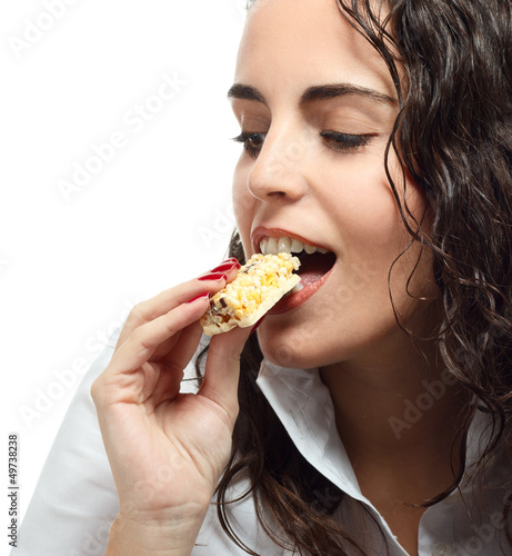 Young woman eating granola bar
