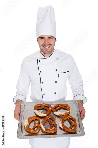 Portrait of happy bakerman with tray photo