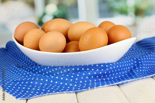 Wallpaper Mural Eggs in white bowl on wooden table on window background Torontodigital.ca