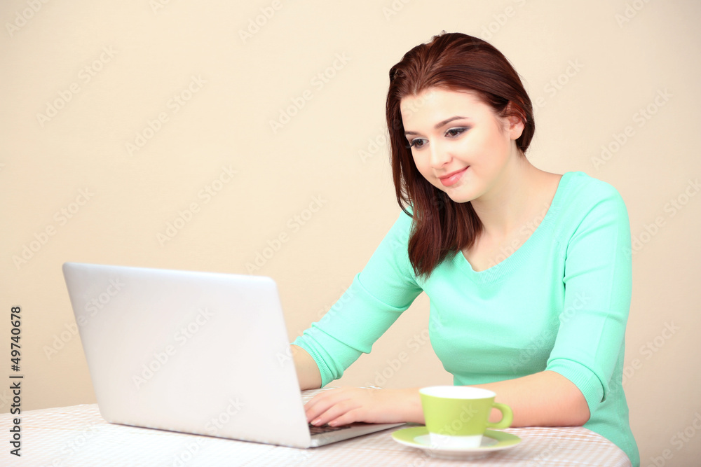 Beautiful young woman working on laptop on light background Beautiful young woman working on laptop on light background