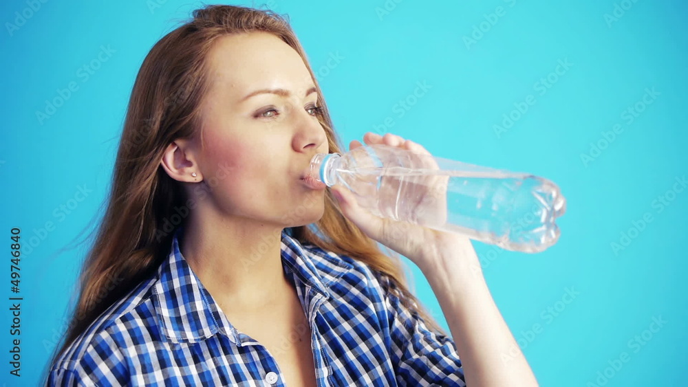 pretty woman drinking water from bottle and smiling pretty woman drinking water from bottle and smiling
