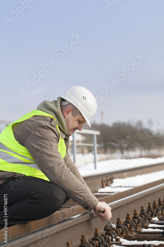 Railroad worker with adjustable wrench fix the nut