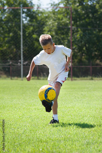 boy kicking football outside © Dusan Kostic