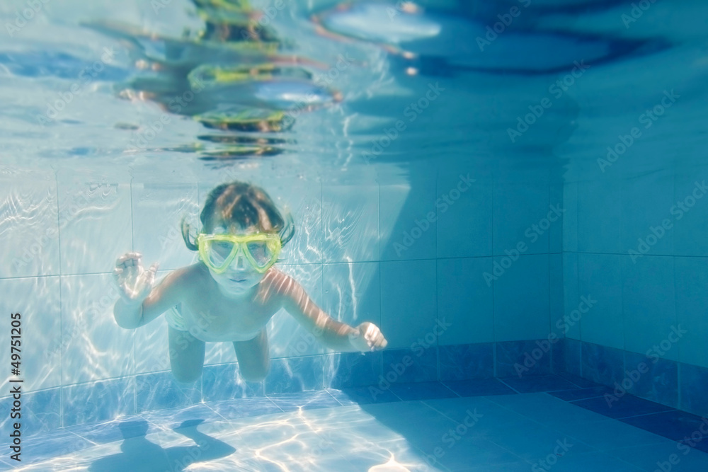 young child girl swimming underwater in pool